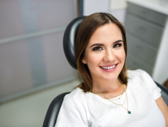 Woman in dental chair smiling and looking up