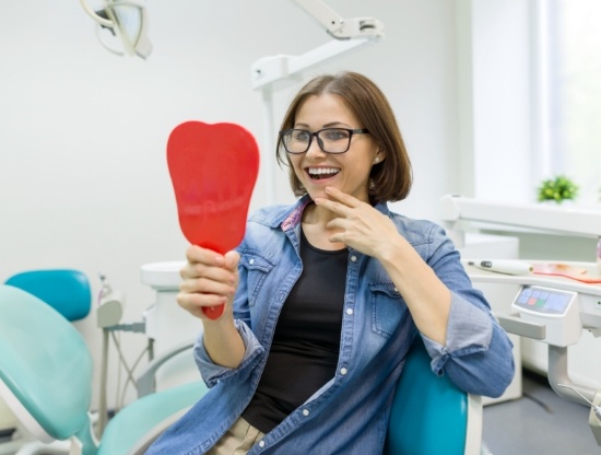 Dental patient looking at her smile in mirror