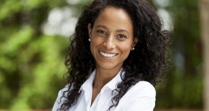 Woman in white collared blouse smiling outdoors