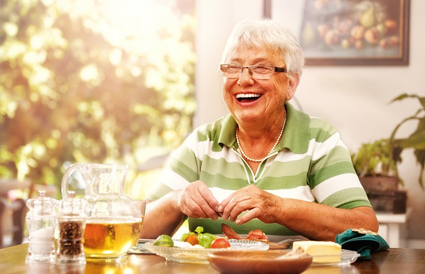 Woman with dentures in Rocky Hill sitting at table smiling