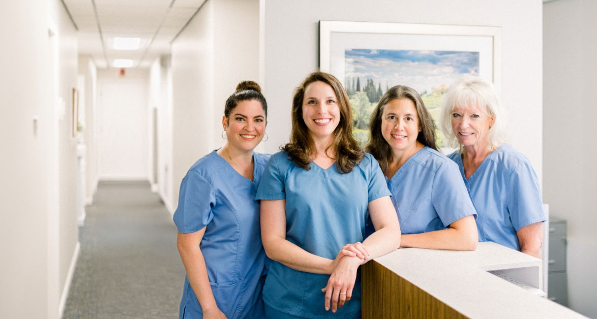 Dental Essentials of Rocky Hill team smiling next to front desk
