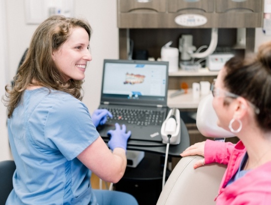 Doctor Karpman talking to a patient next to computer showing digital model of teeth