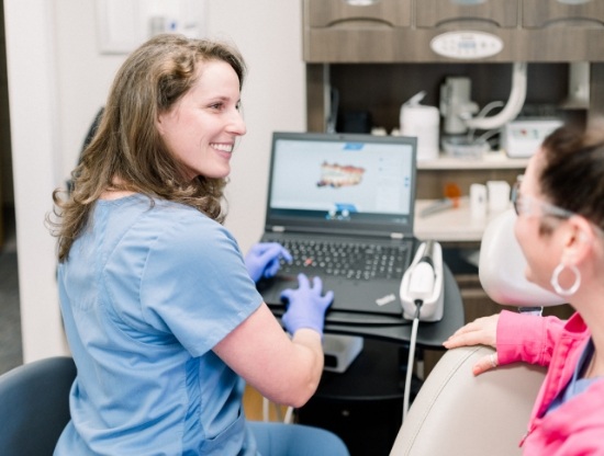 Doctor Karpman smiling while talking to a patient in the dental chair