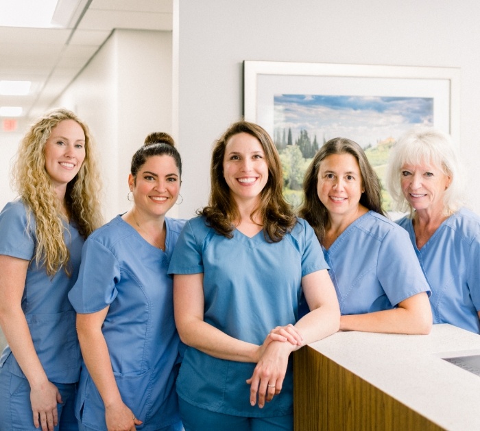Smiling Rocky Hill dental team members in front of front desk
