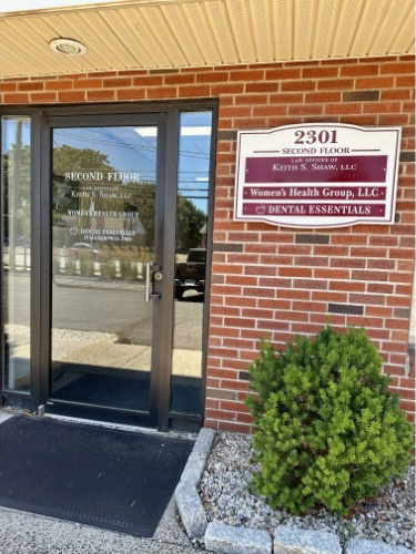 The Dental Essentials sign mounted on a brick building, showcasing the dental practice's name and services