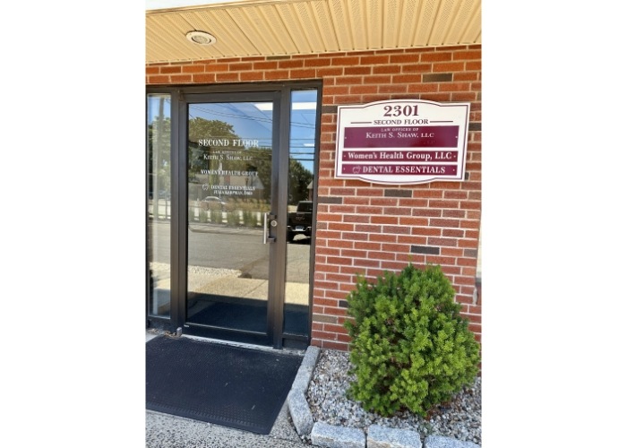 The Dental Essentials sign mounted on a brick building, showcasing the dental practice's name and services