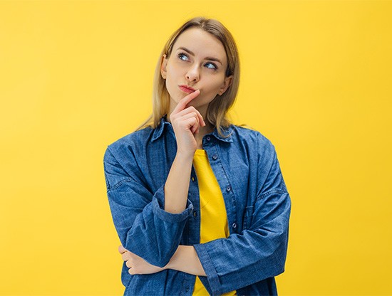 Woman in yellow t-shirt wearing curious expression