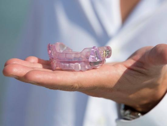 Dentist holding an occlusal splint tray for T M J treatment