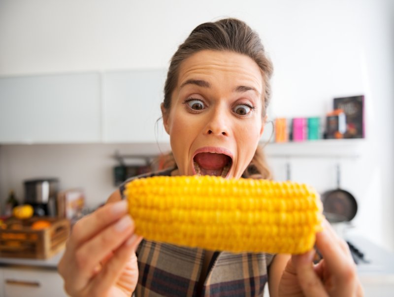 woman biting into corn on the cob