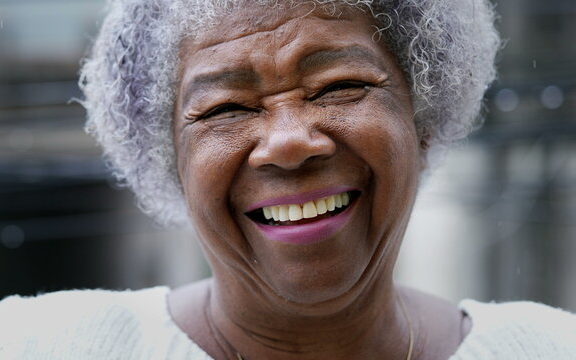 patient smiling after having ill-fitting dentures fixed 