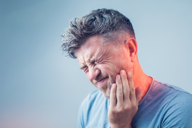 young man suffering from tooth pain