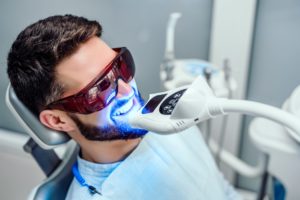 Man with dark hair having in-office teeth whitening procedure